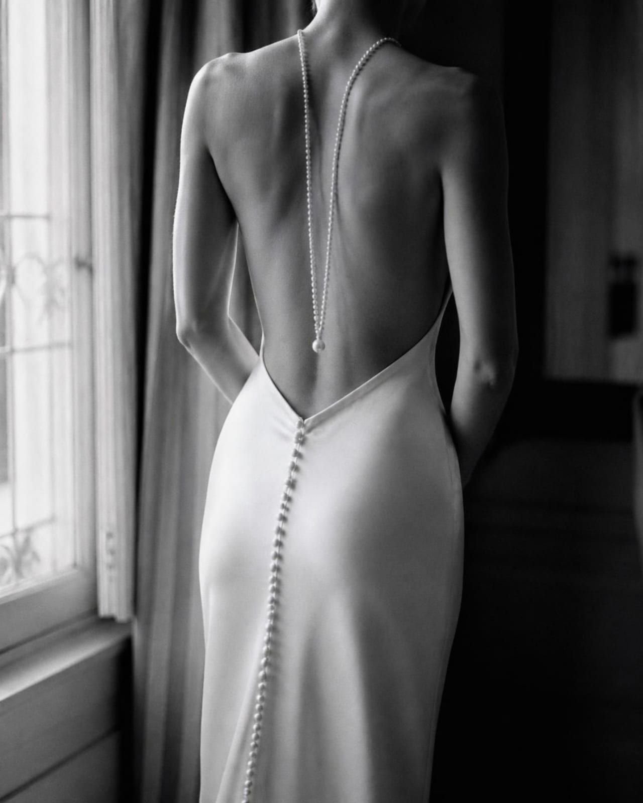 Espalda de un vestido de novia de seda con una hilera de botones de perla, en blanco y negro
